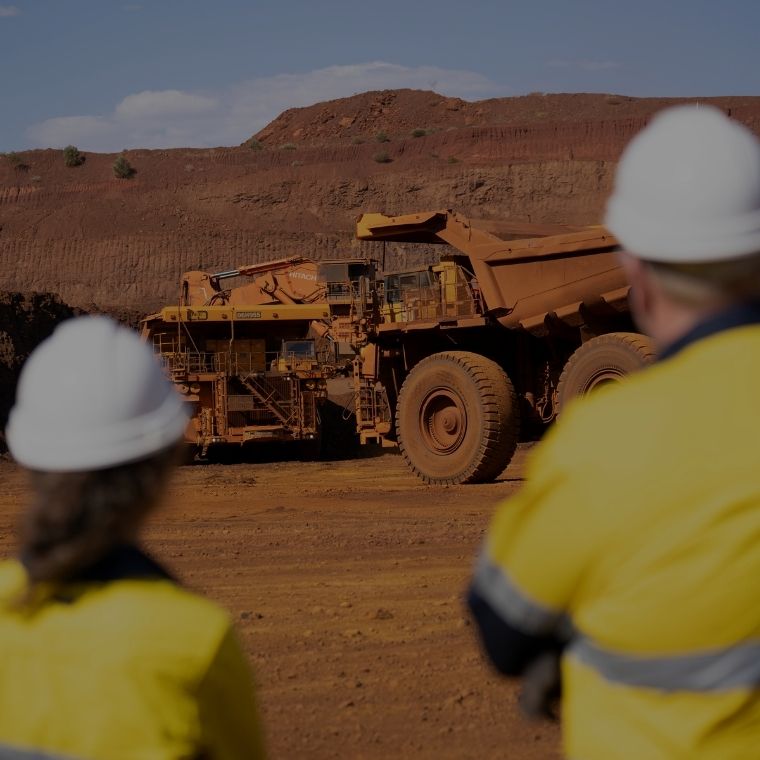 Two people on mine site looking at machines